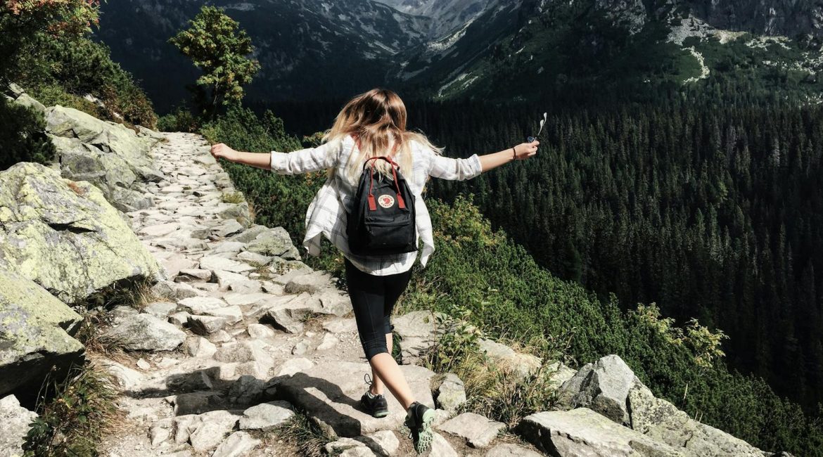 Woman hikes along rocky path in Vysoké Tatry, Slovakia. Embracing nature and freedom